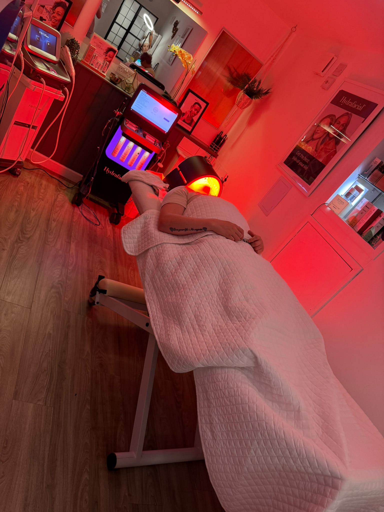LED light therapy during a facial, the client resting under the LED mask in the treatment room
